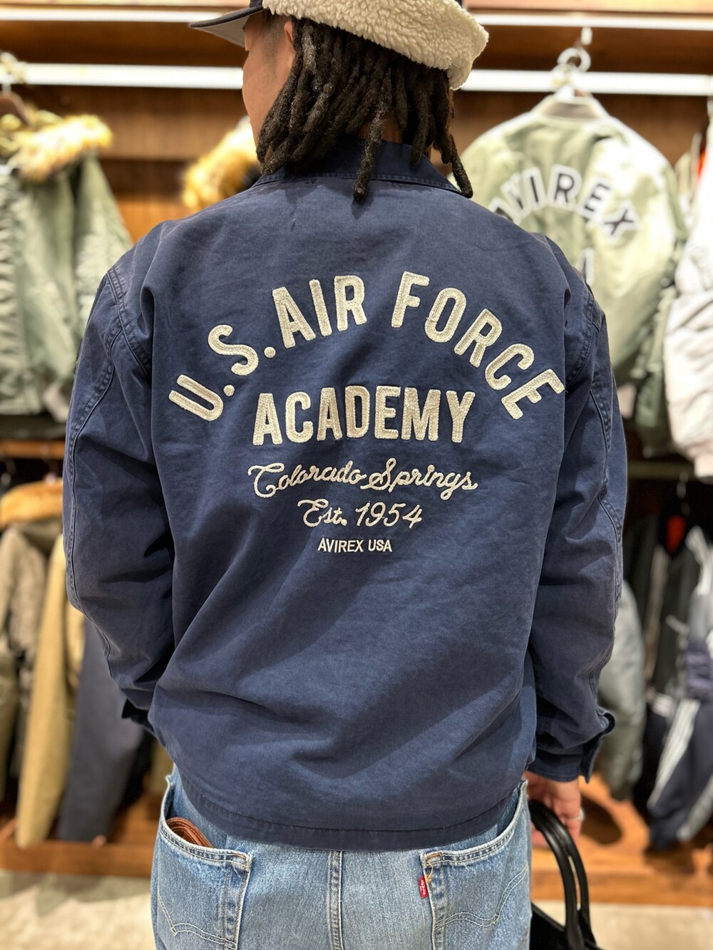 ブラック系のトートバッグ、ホワイト系のTシャツ/カットソーを着用したメンズの冬コーディネートの3枚目の写真