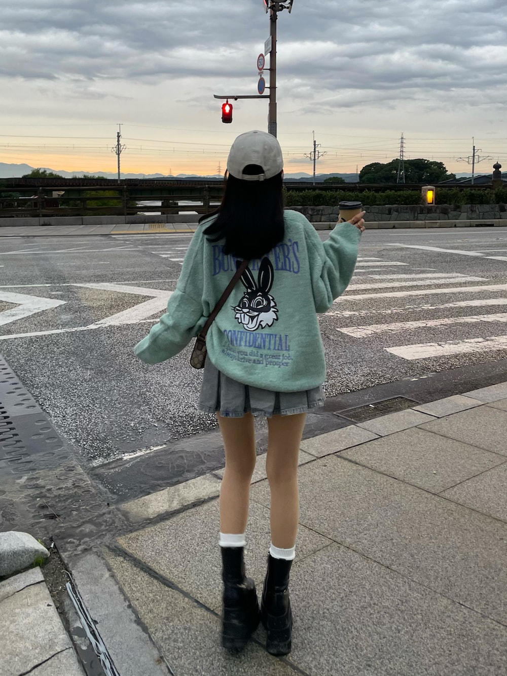 グリーン系のニット/セーター、ブルー系のデニムスカート、ブラック系のブーツを着用したレディースの秋コーディネートの3枚目の写真