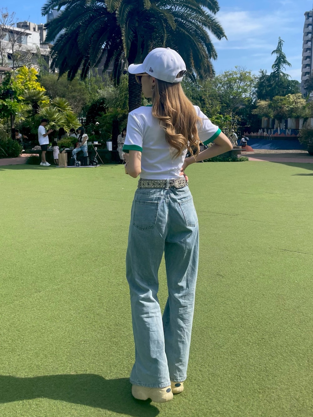 ホワイト系のTシャツ/カットソー、ブルー系のデニムパンツ、ホワイト系のスニーカーを着用したレディースの夏コーディネートの3枚目の写真