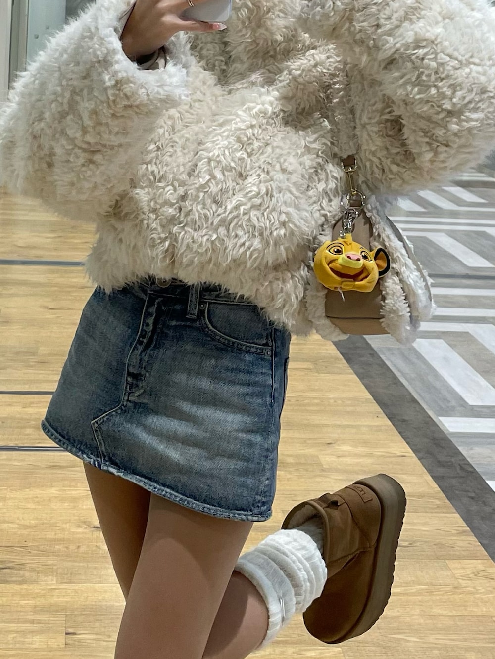 ホワイト系のブルゾン、ベージュ系のショルダーバッグ、ブルー系のデニムスカートを着用したレディースの夏コーディネートの3枚目の写真