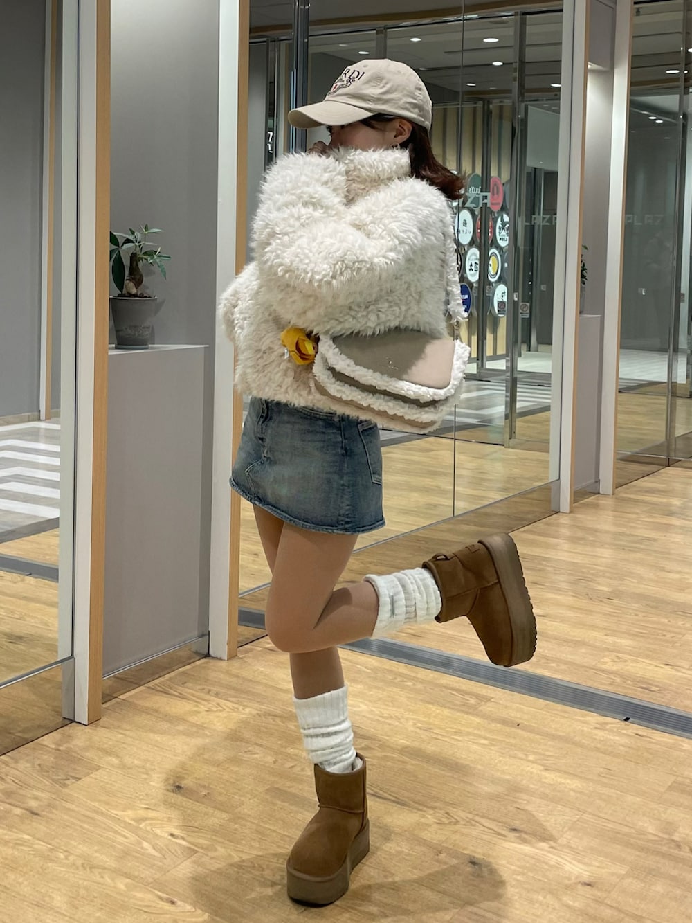 ホワイト系のブルゾン、ベージュ系のショルダーバッグ、ブルー系のデニムスカートを着用したレディースの夏コーディネートの5枚目の写真