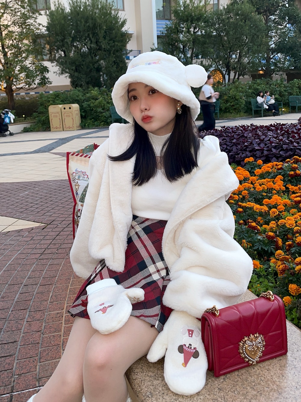 ホワイト系のニット/セーター、レッド系のスカート、ホワイト系のブーツを着用したレディースの冬コーディネートの2枚目の写真