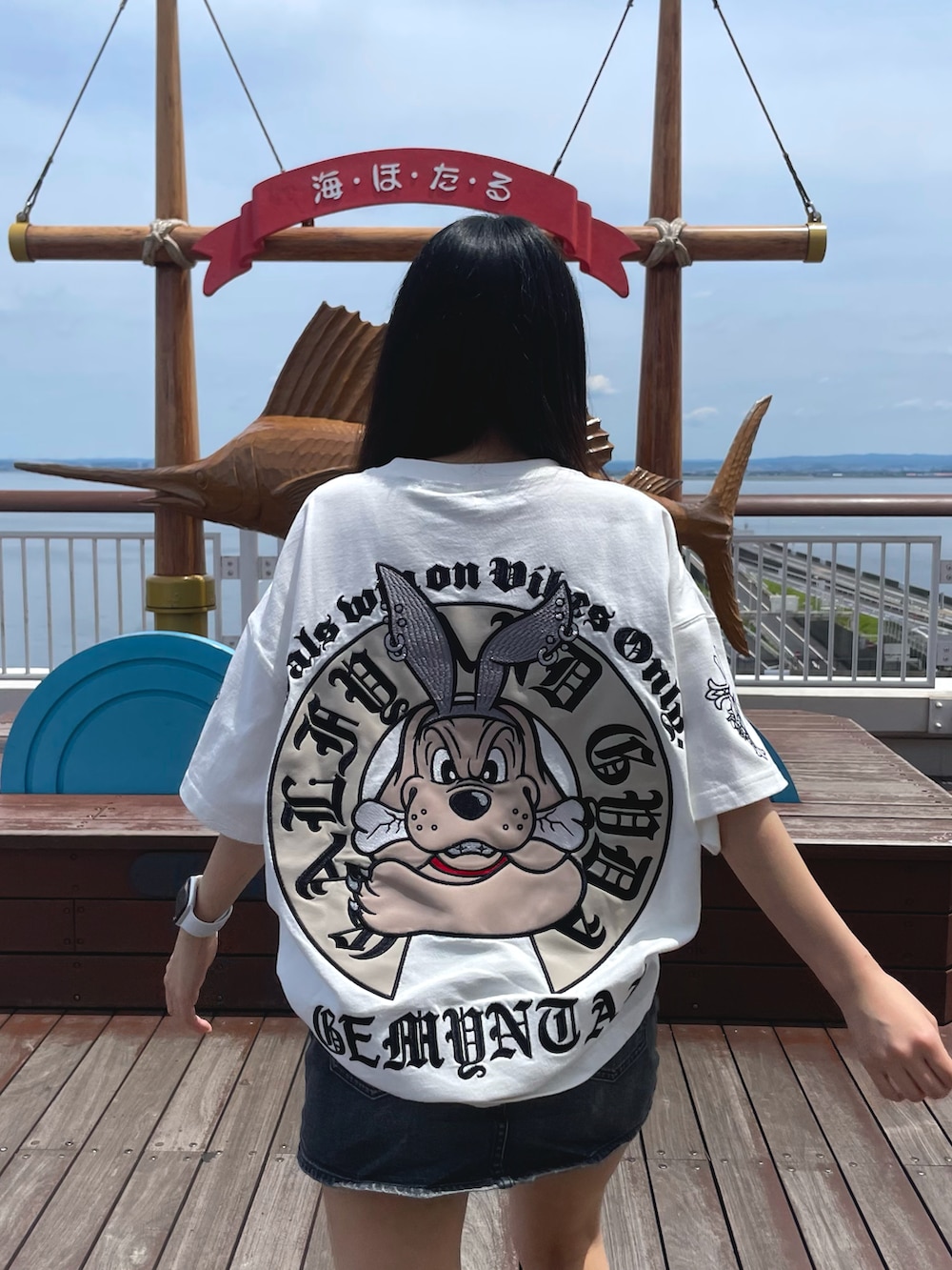 ホワイト系のTシャツ/カットソー、ブラック系のデニムスカート、ブラック系のサンダルを着用したレディースの夏コーディネートの5枚目の写真