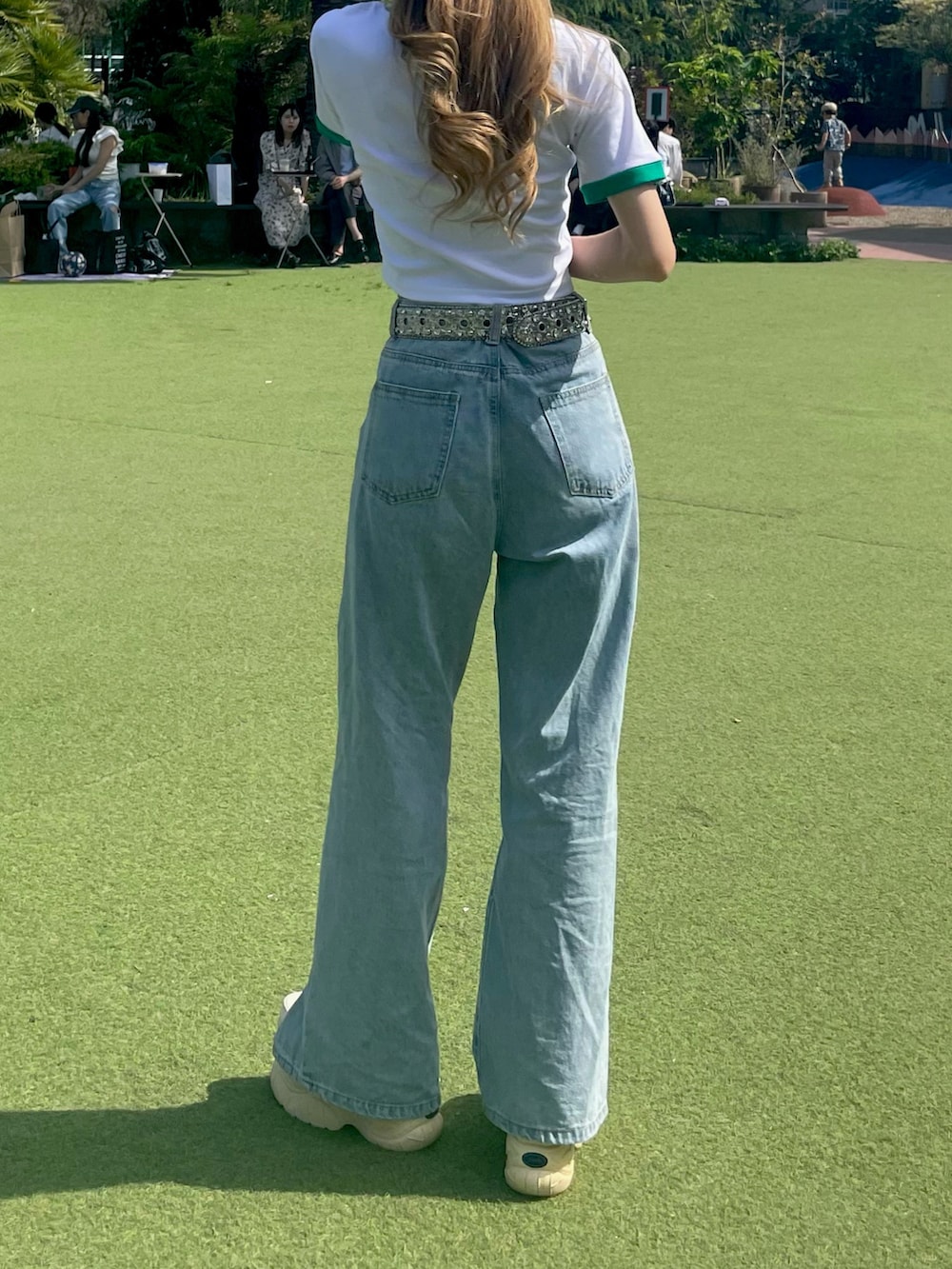 ホワイト系のTシャツ/カットソー、ブルー系のデニムパンツ、ホワイト系のスニーカーを着用したレディースの夏コーディネートの4枚目の写真