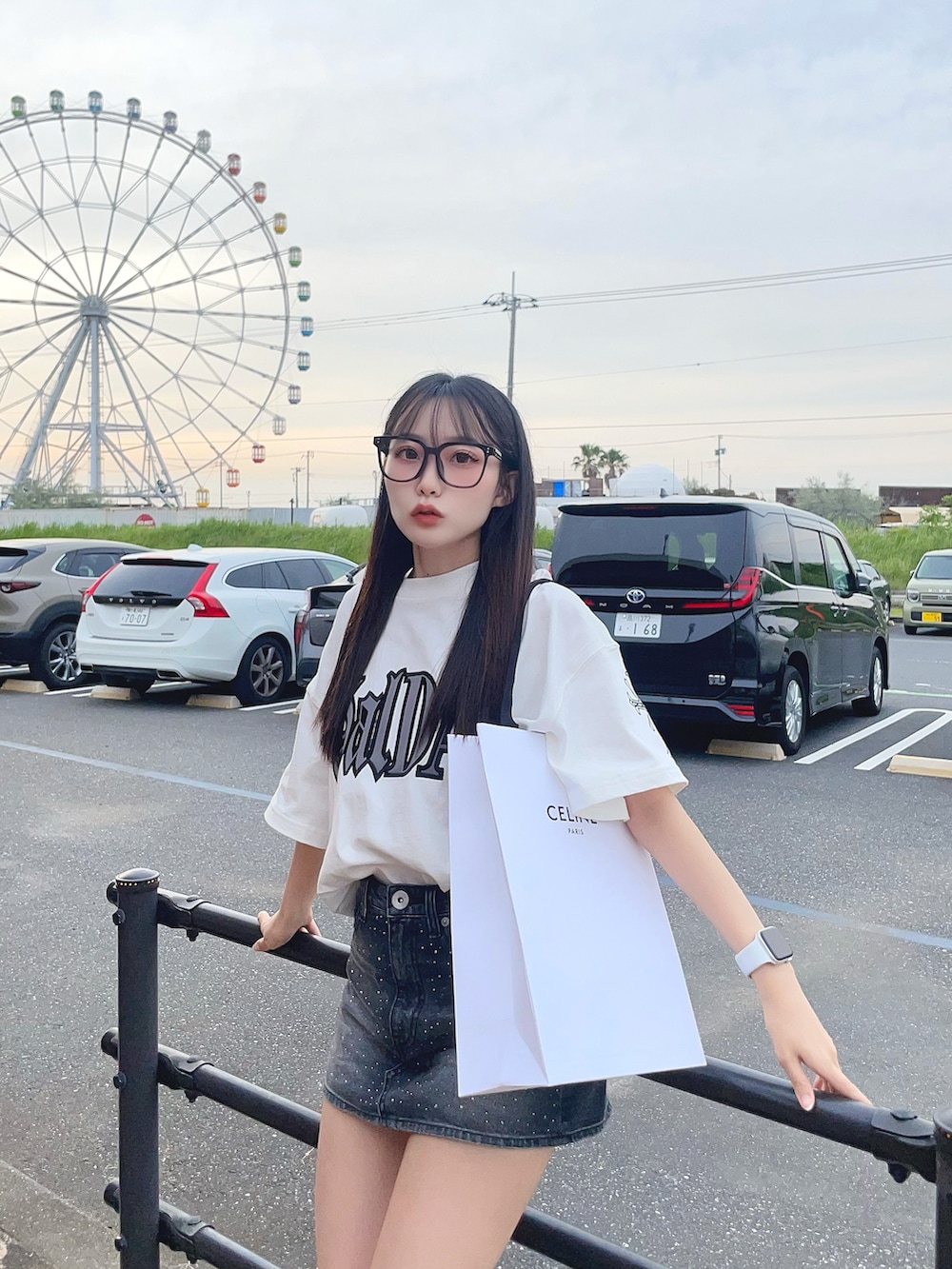 ホワイト系のTシャツ/カットソー、ブラック系のデニムスカート、ブラック系のサンダルを着用したレディースの夏コーディネートの3枚目の写真