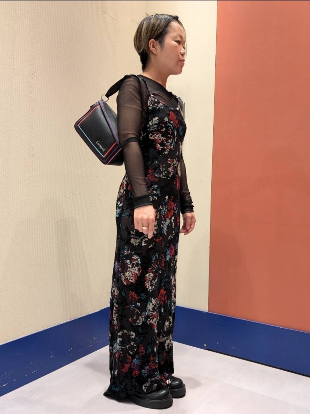 ブラック系のワンピース、ブラック系のブーツ、ブラック系のハンドバッグを着用したレディースの秋コーディネートの2枚目の写真