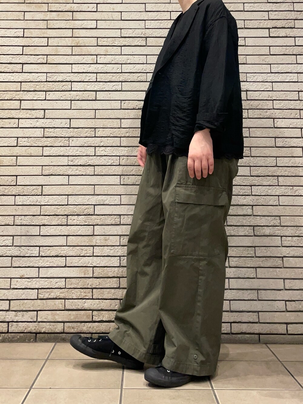 ブラック系のその他アウター、グリーン系のその他パンツ、ブラック系のシャツ/ブラウスを着用したレディースの秋コーディネートの6枚目の写真