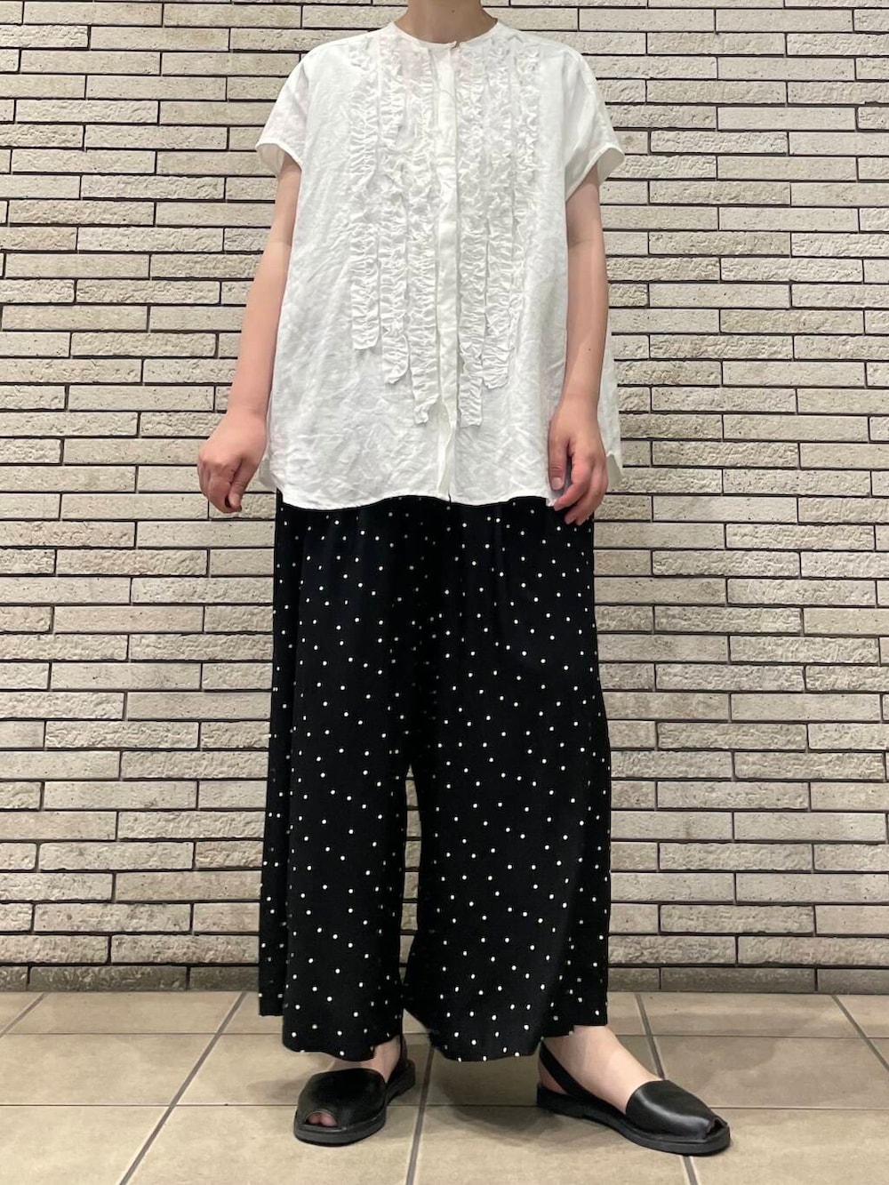 ブラック系のその他パンツ、ホワイト系のシャツ/ブラウスを着用したレディースの夏コーディネートの2枚目の写真