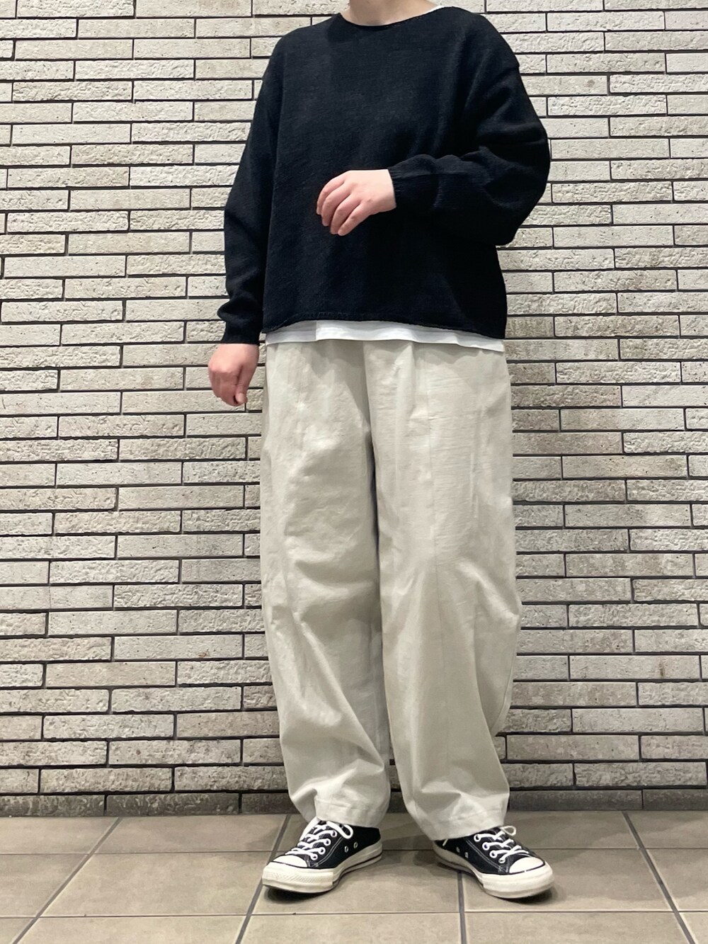 ブラック系のニット/セーター、ホワイト系のその他パンツを着用したレディースの秋コーディネートの4枚目の写真