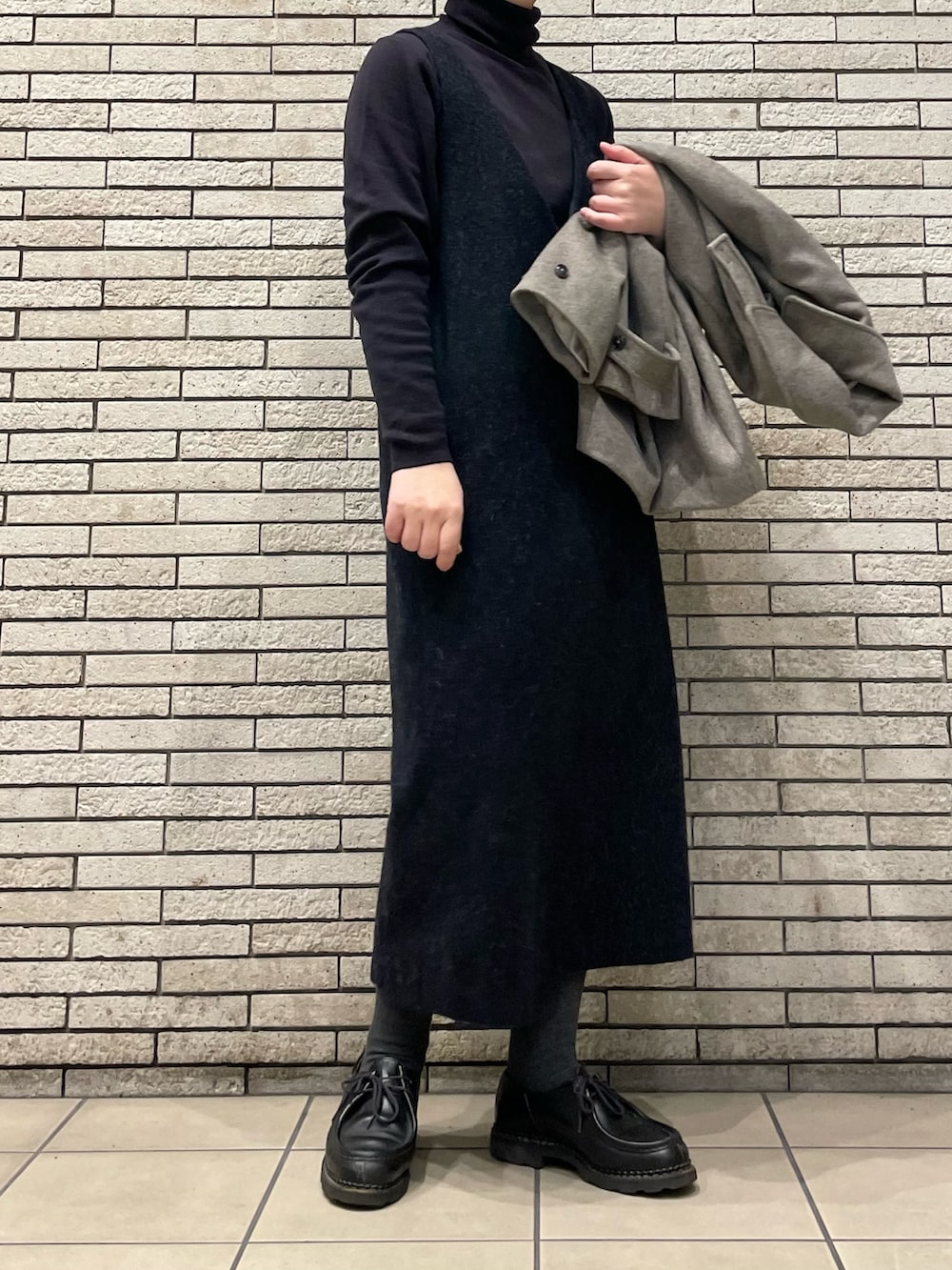 グレー系のステンカラーコート、グレー系のワンピースを着用したレディースの秋コーディネートの7枚目の写真