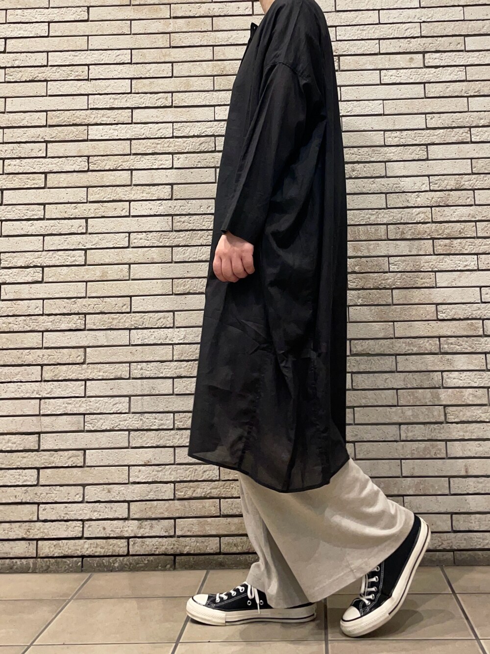 ブラック系のチュニック、ベージュ系のその他パンツを着用したレディースの夏コーディネートの3枚目の写真