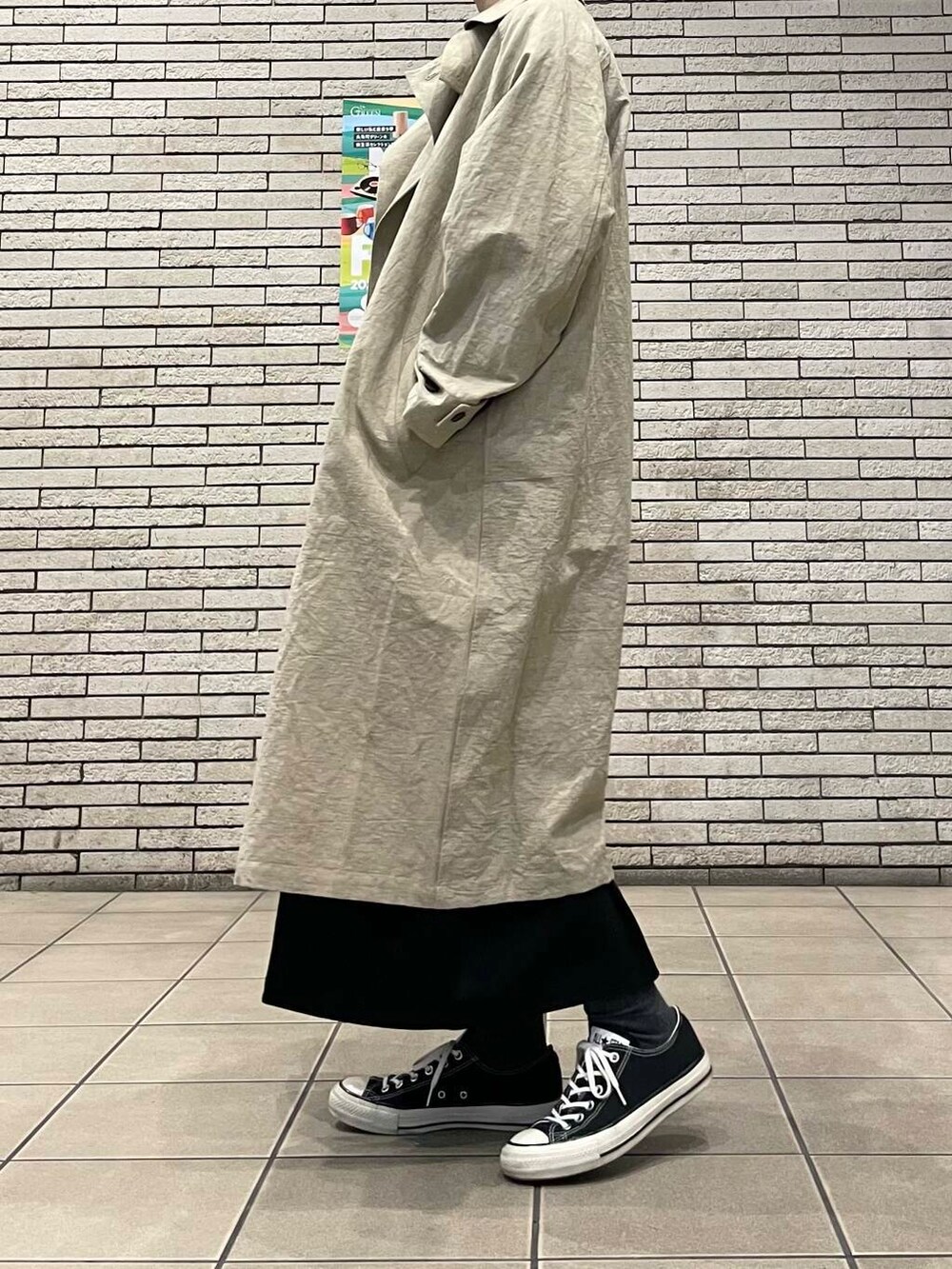 ベージュ系のトレンチコートを着用したレディースの春コーディネートの3枚目の写真