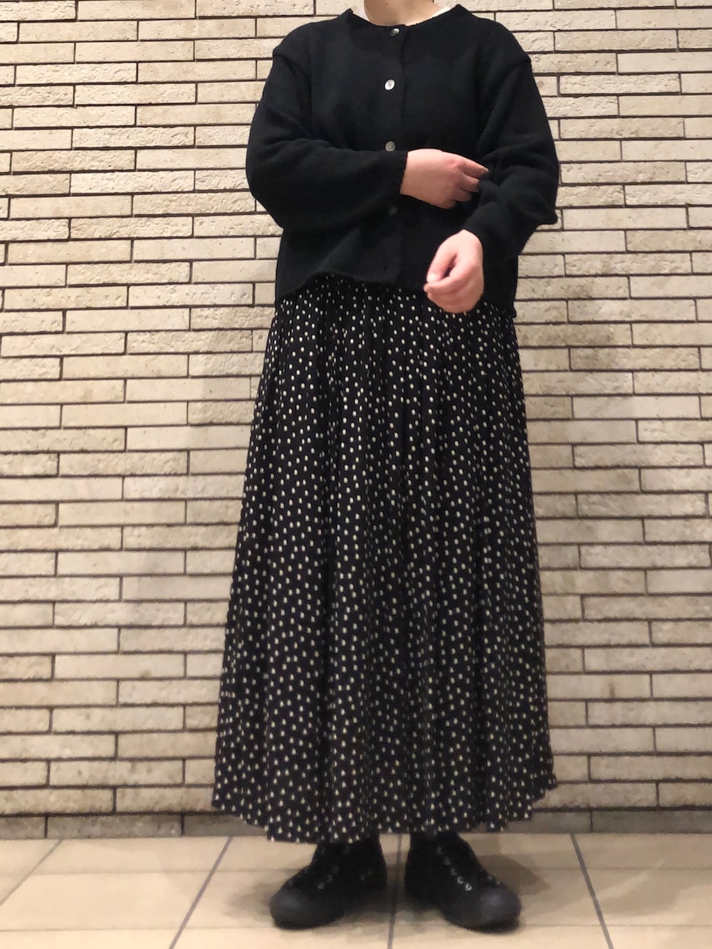 ブラック系のカーディガン/ボレロ、ブラック系のスカートを着用したレディースの冬コーディネートの4枚目の写真