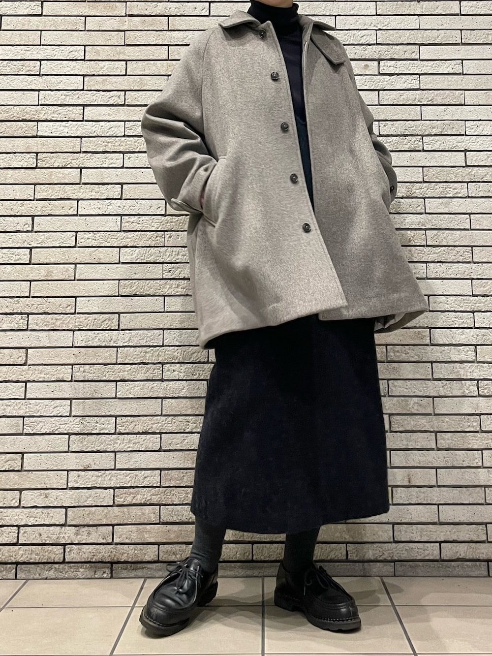 グレー系のステンカラーコート、グレー系のワンピースを着用したレディースの秋コーディネートの4枚目の写真