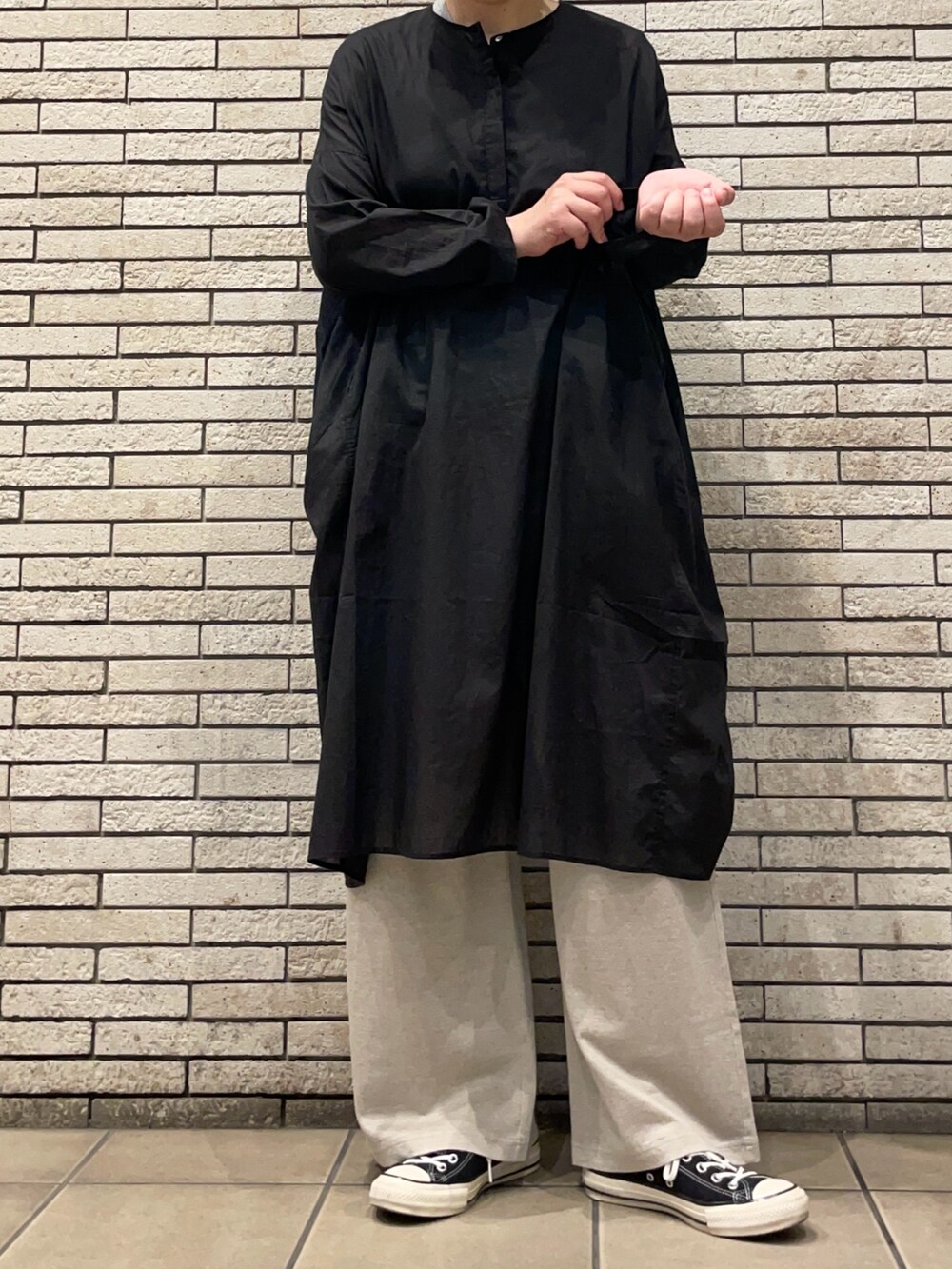 ブラック系のチュニック、ベージュ系のその他パンツを着用したレディースの夏コーディネートの4枚目の写真