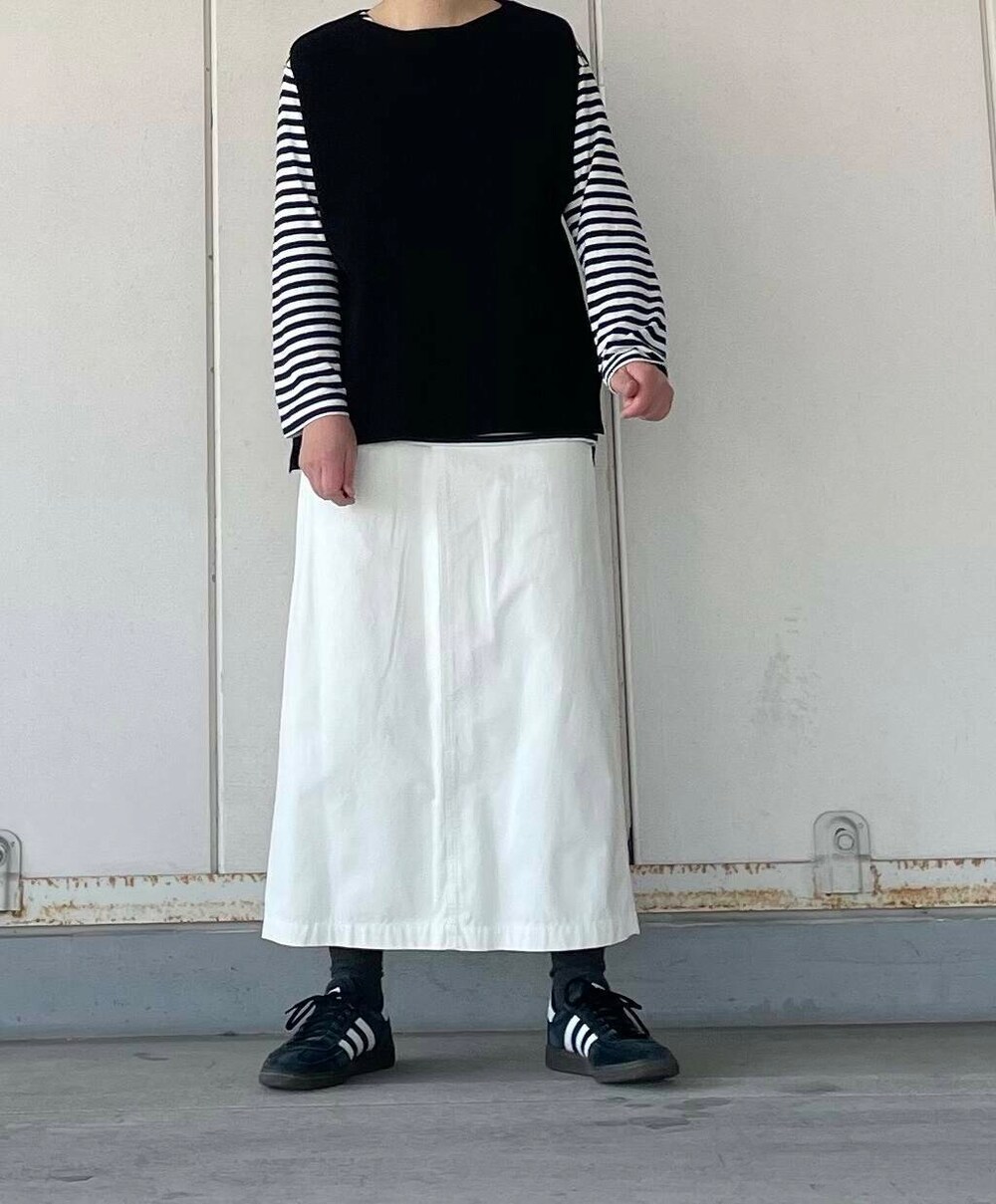 ホワイト系のスカート、ブラック系のベストを着用したレディースの冬コーディネートの5枚目の写真
