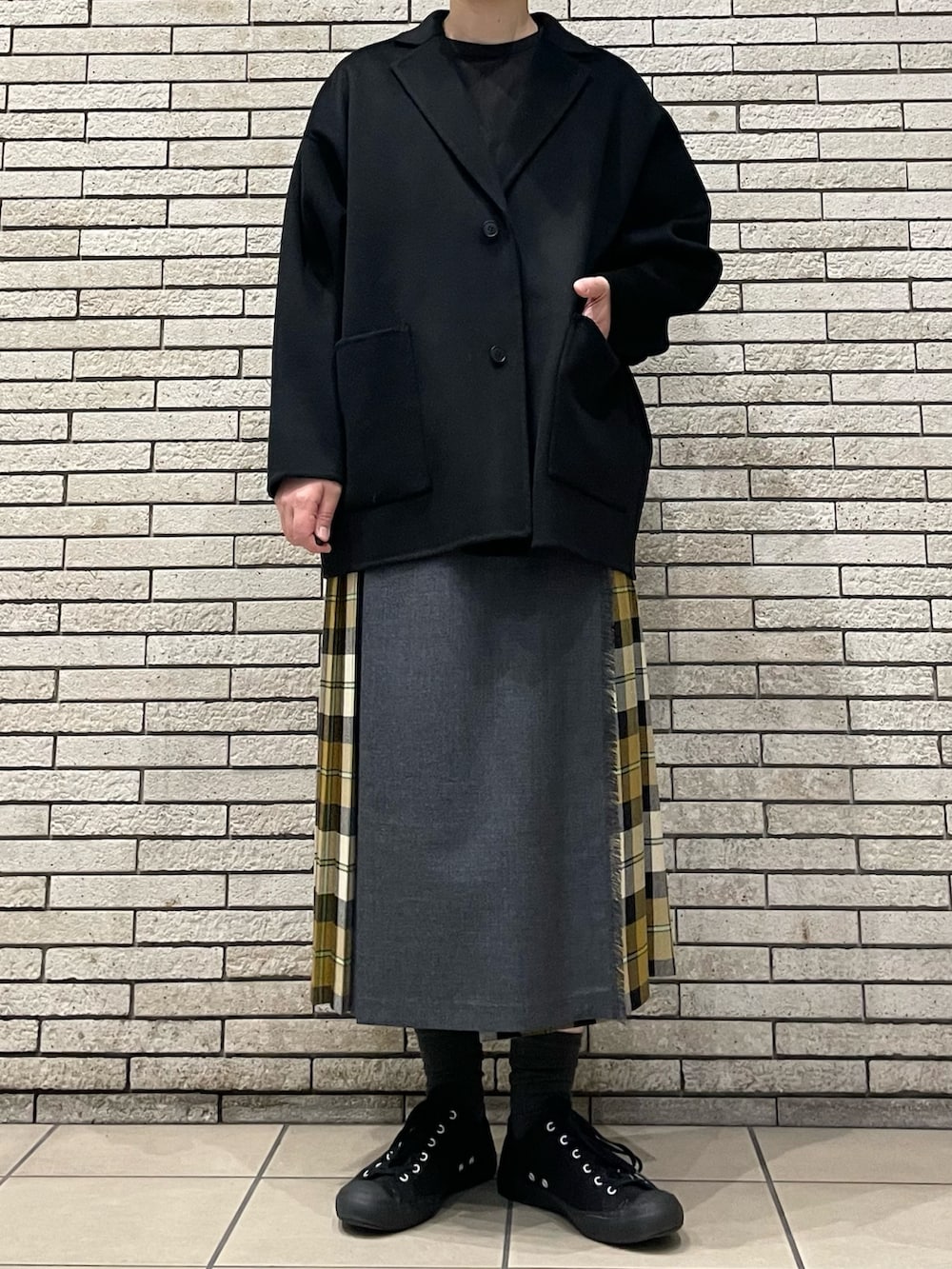 ブラック系のその他アウター、ベージュ系のスカートを着用したレディースの秋コーディネートの2枚目の写真