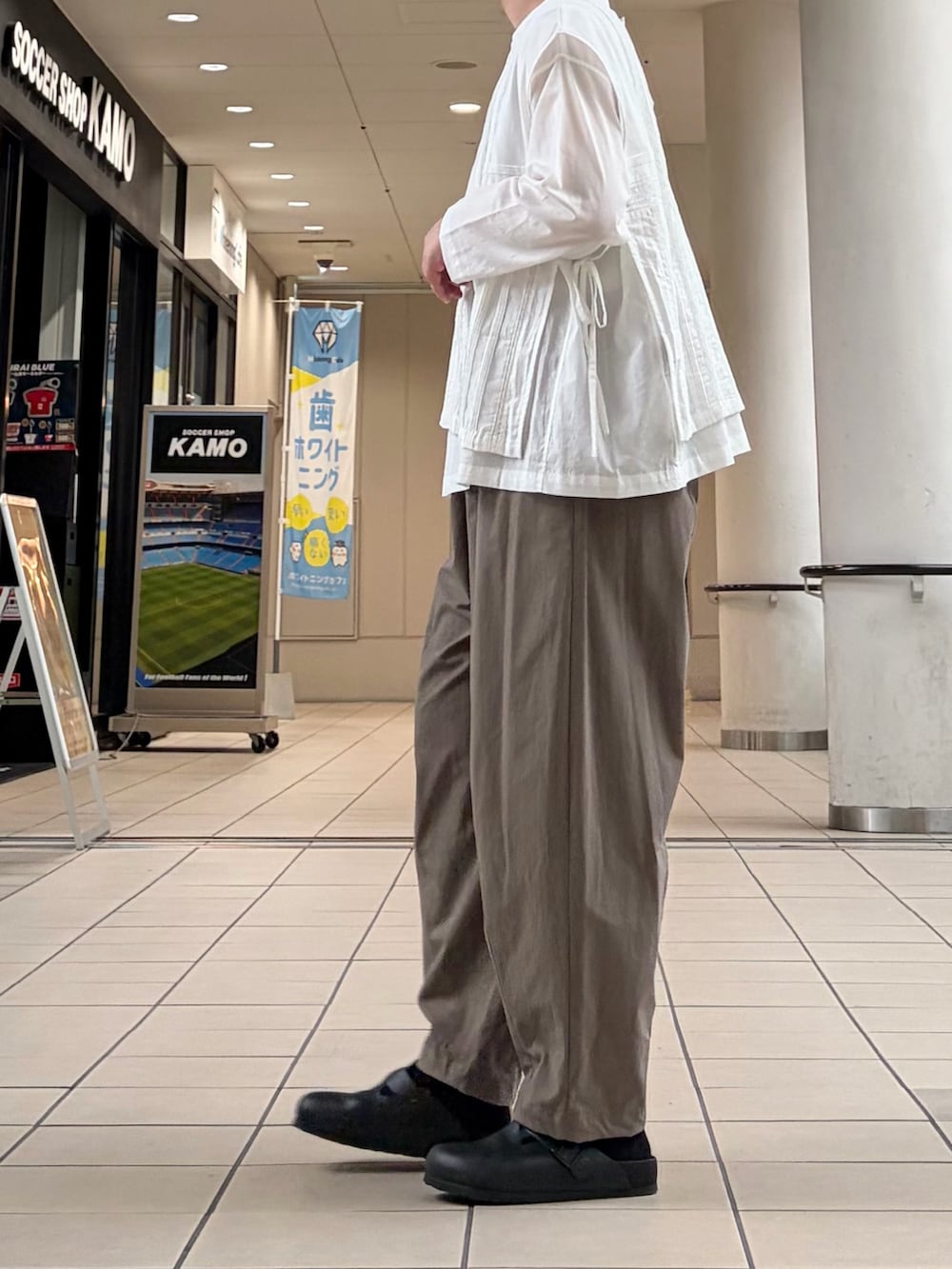ホワイト系のシャツ/ブラウス、グリーン系のその他パンツ、イエロー系のハンドバッグを着用したレディースの秋コーディネートの6枚目の写真
