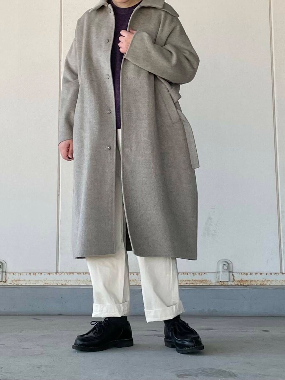 ベージュ系のデニムパンツ、グレー系のステンカラーコート、パープル系のニット/セーターを着用したレディースの冬コーディネートの3枚目の写真