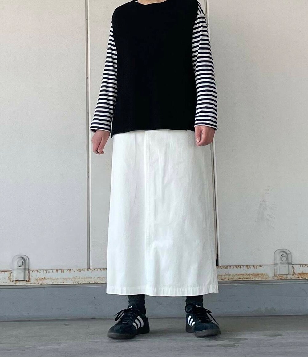 ホワイト系のスカート、ブラック系のベストを着用したレディースの冬コーディネートの4枚目の写真