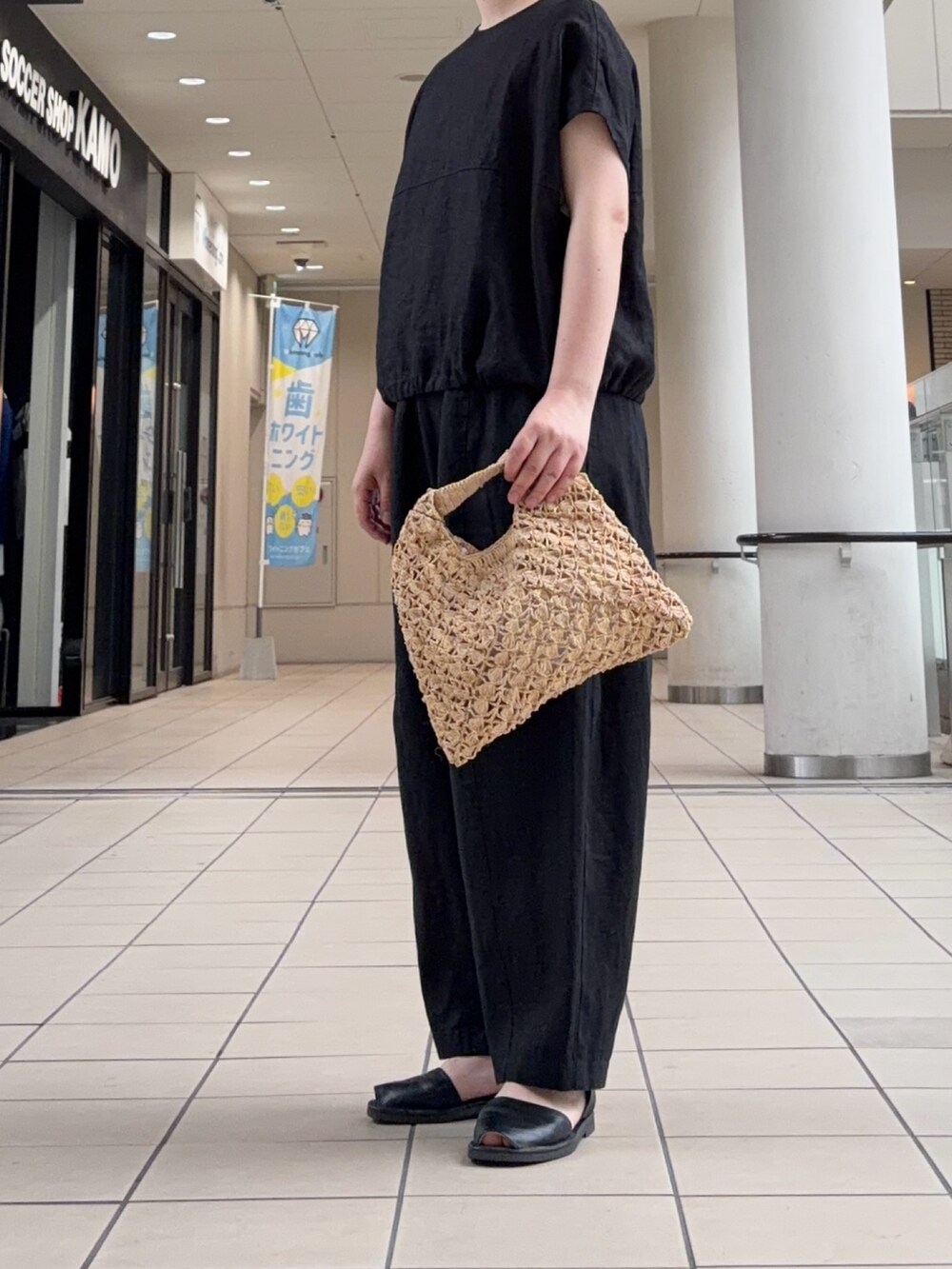 ブラック系のシャツ/ブラウス、ベージュ系のハンドバッグ、ブラック系のその他パンツを着用したレディースの夏コーディネートの3枚目の写真