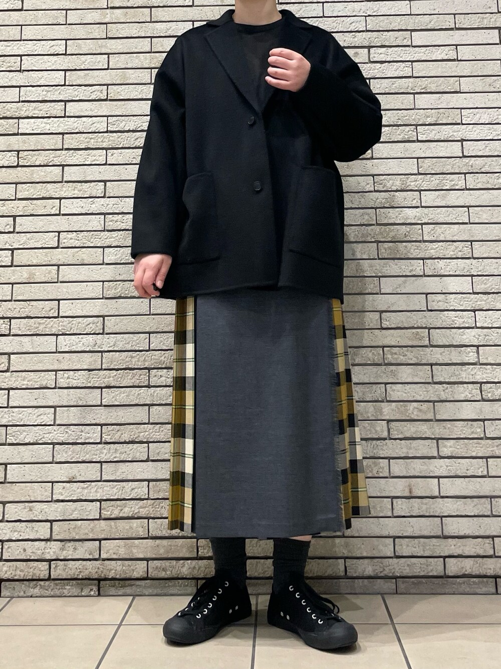 ブラック系のその他アウター、ベージュ系のスカートを着用したレディースの秋コーディネートの7枚目の写真