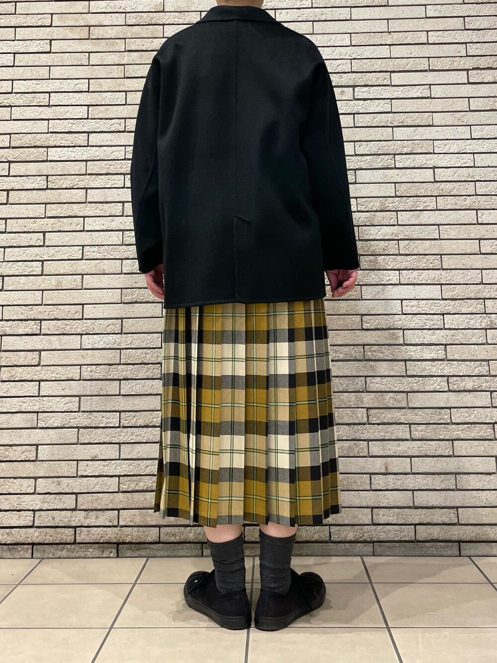 ブラック系のその他アウター、ベージュ系のスカートを着用したレディースの秋コーディネートの6枚目の写真