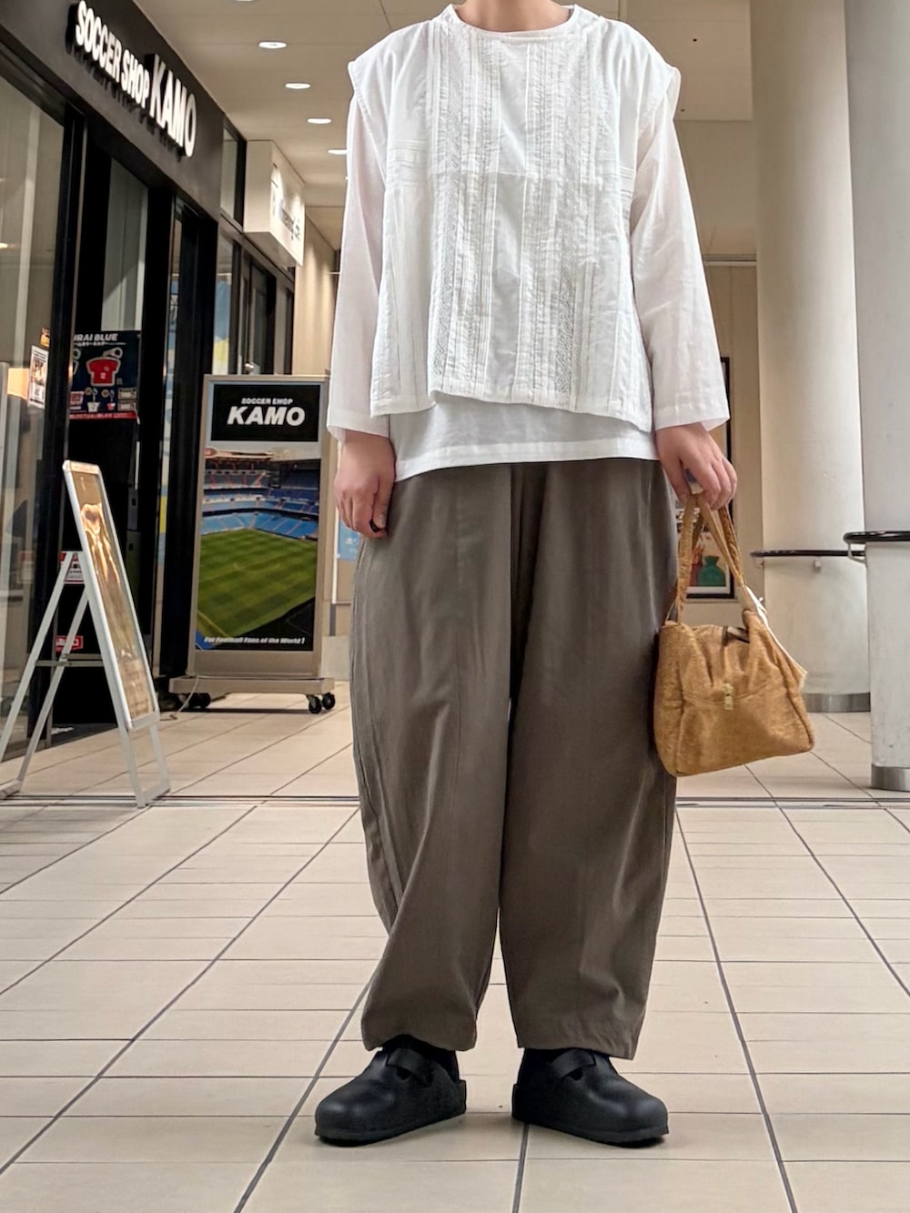 ホワイト系のシャツ/ブラウス、グリーン系のその他パンツ、イエロー系のハンドバッグを着用したレディースの秋コーディネートの2枚目の写真
