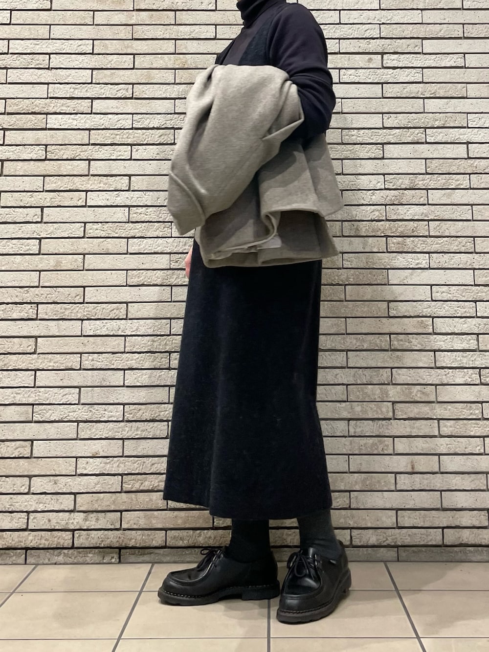 グレー系のステンカラーコート、グレー系のワンピースを着用したレディースの秋コーディネートの6枚目の写真