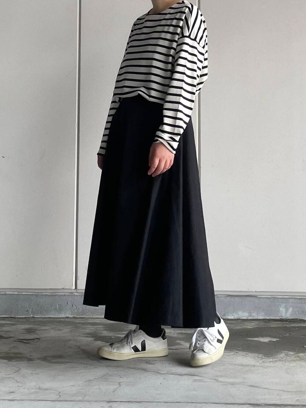 ブラック系のスカート、ホワイト系のTシャツ/カットソーを着用したレディースの秋コーディネートの4枚目の写真