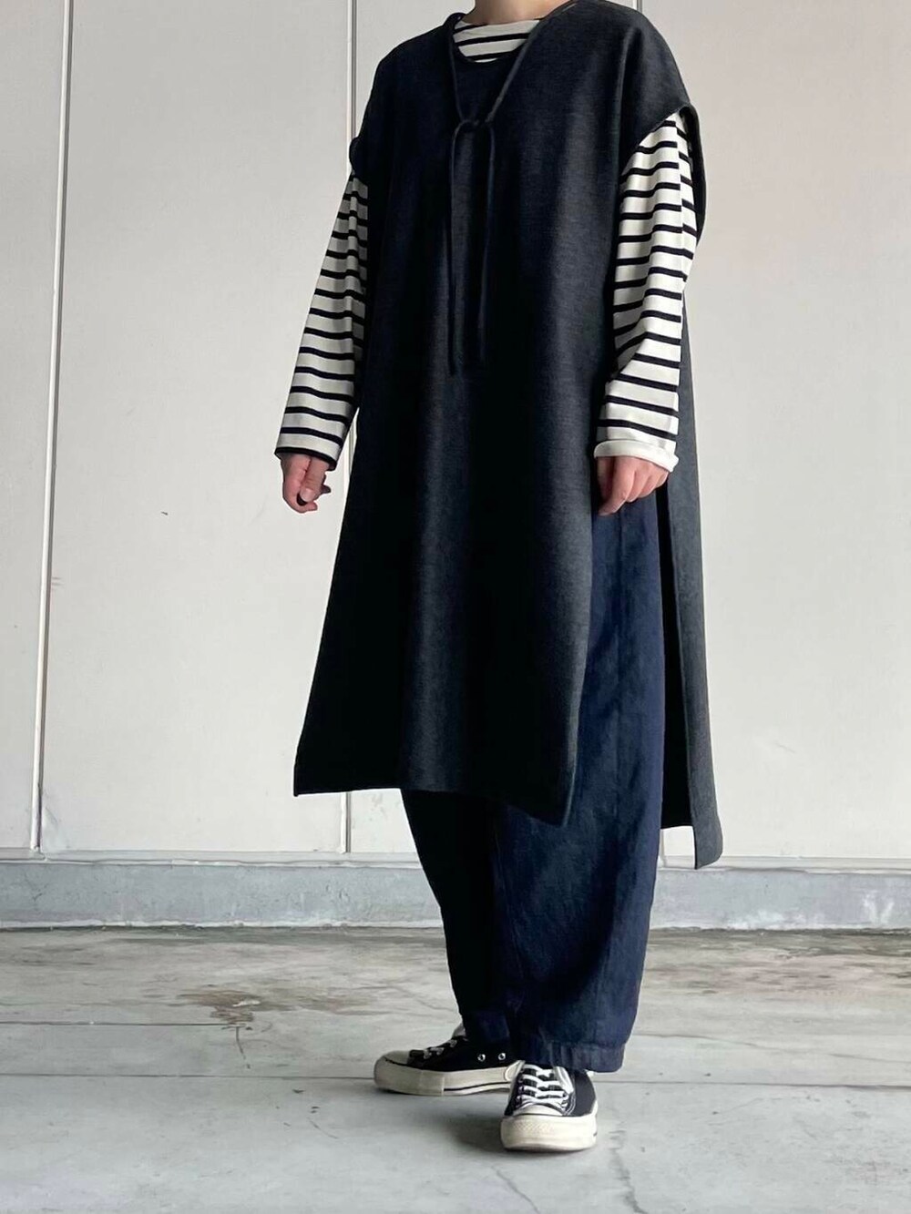 ブルー系のデニムパンツ、ホワイト系のTシャツ/カットソー、グレー系のワンピースを着用したレディースの秋コーディネートの3枚目の写真