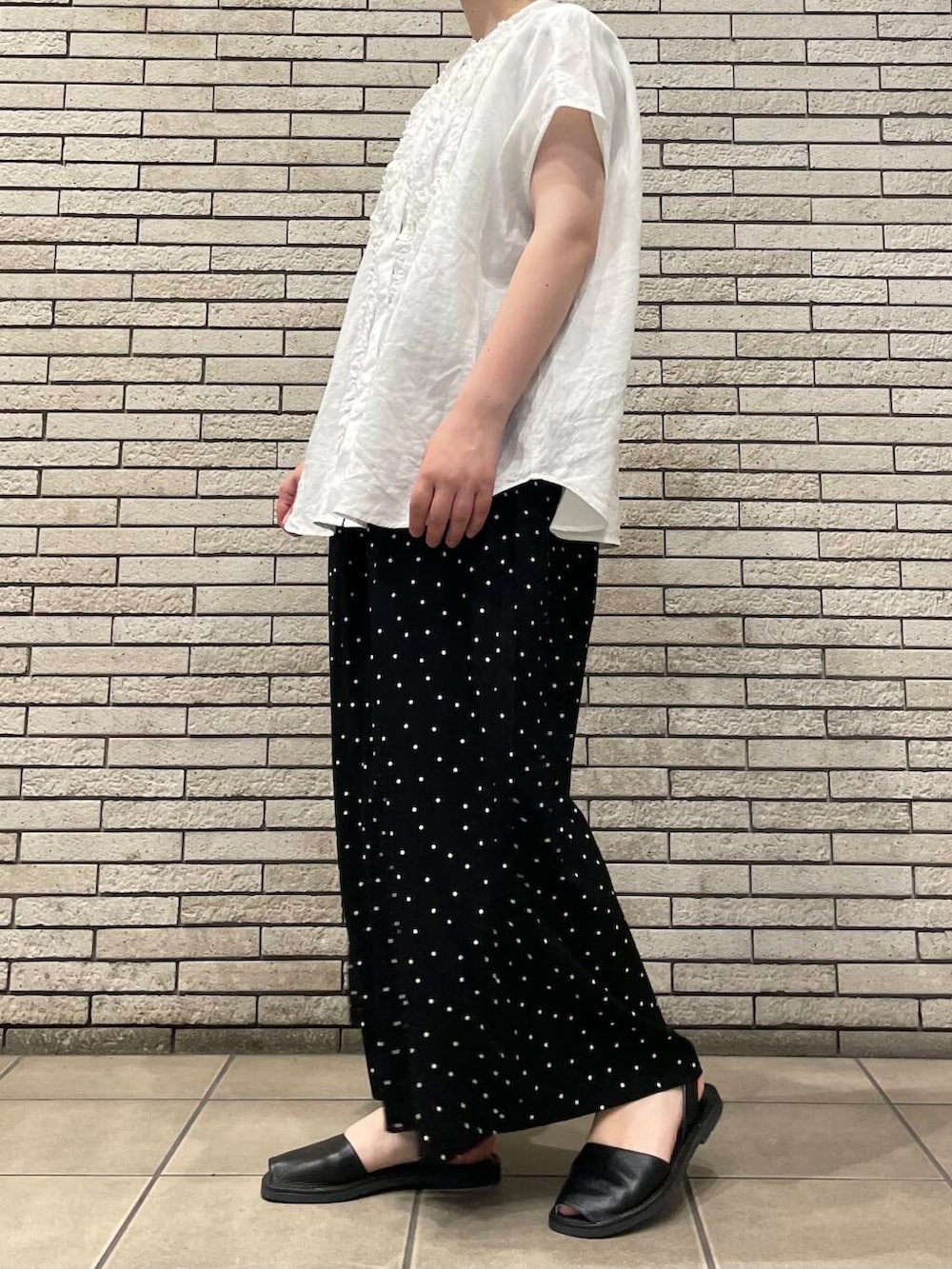 ブラック系のその他パンツ、ホワイト系のシャツ/ブラウスを着用したレディースの夏コーディネートの3枚目の写真