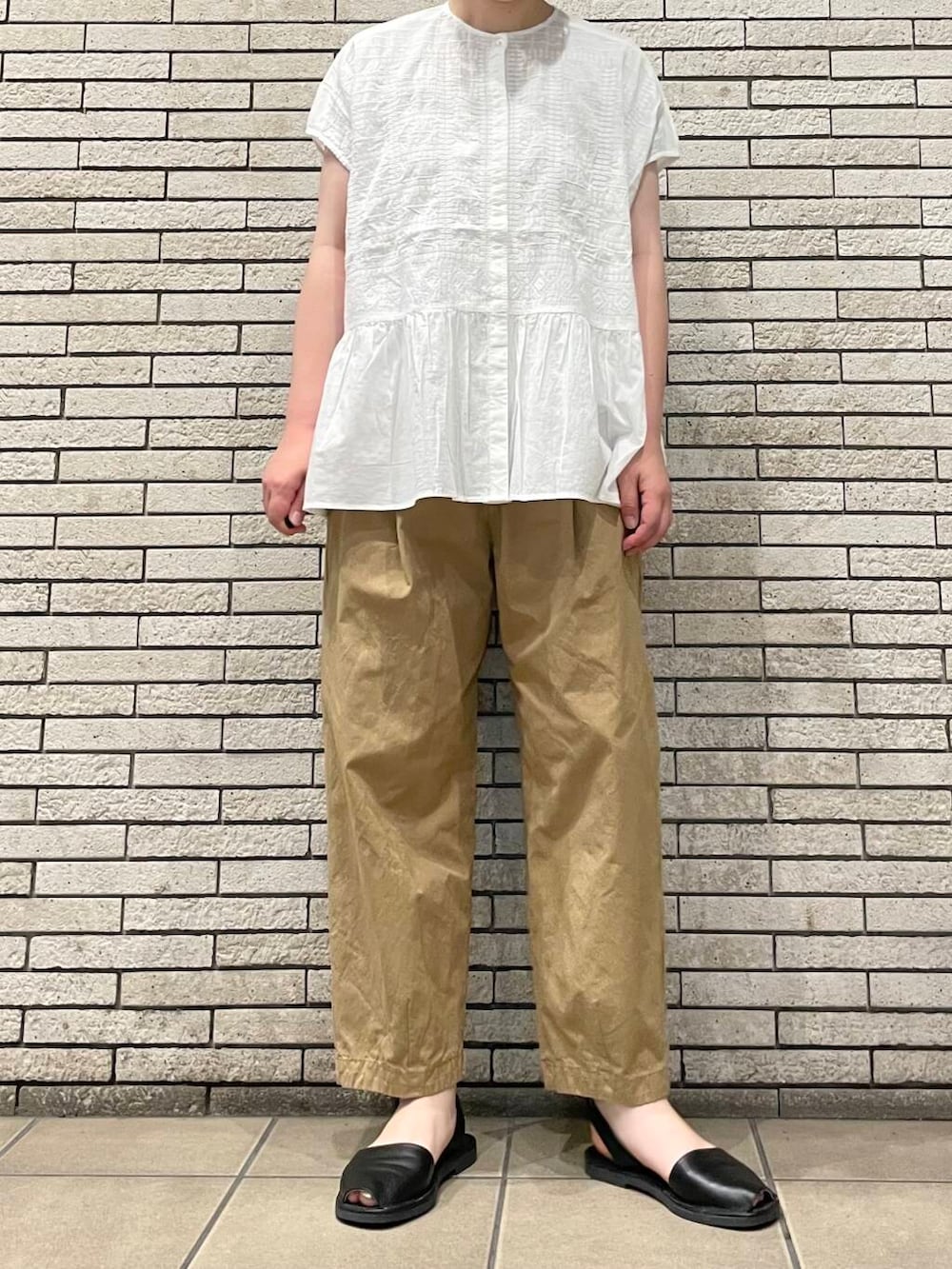 ベージュ系のその他パンツ、ホワイト系のシャツ/ブラウスを着用したレディースの夏コーディネートの2枚目の写真