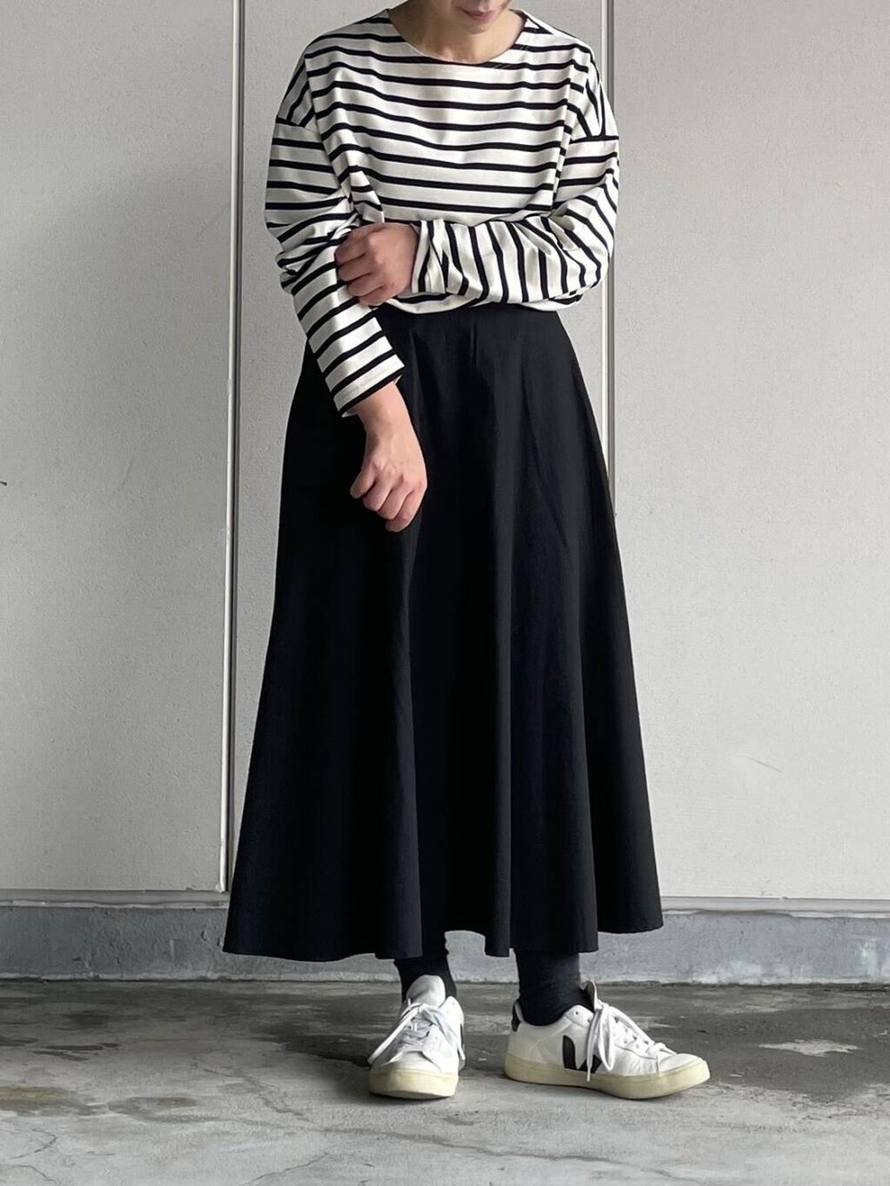 ブラック系のスカート、ホワイト系のTシャツ/カットソーを着用したレディースの秋コーディネートの3枚目の写真