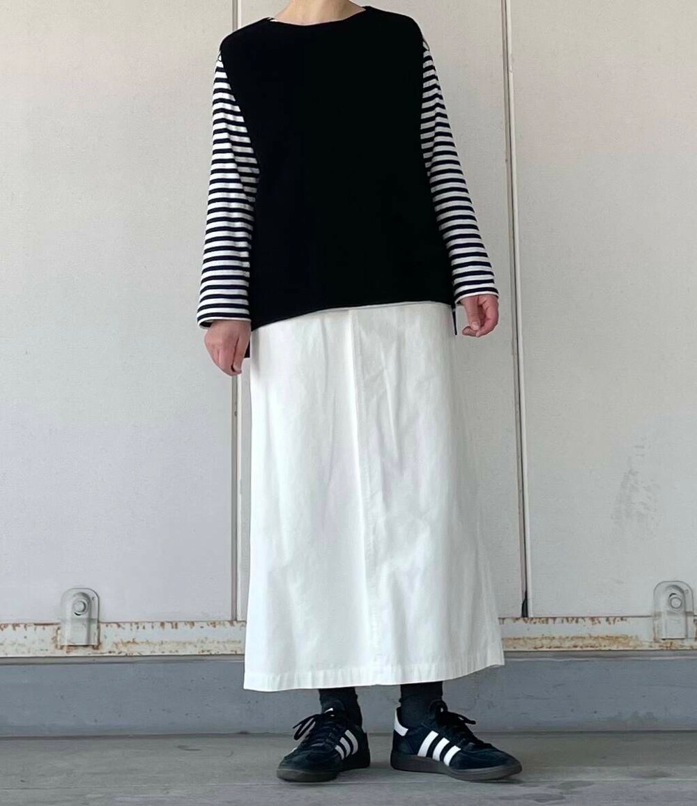 ホワイト系のスカート、ブラック系のベストを着用したレディースの冬コーディネートの3枚目の写真