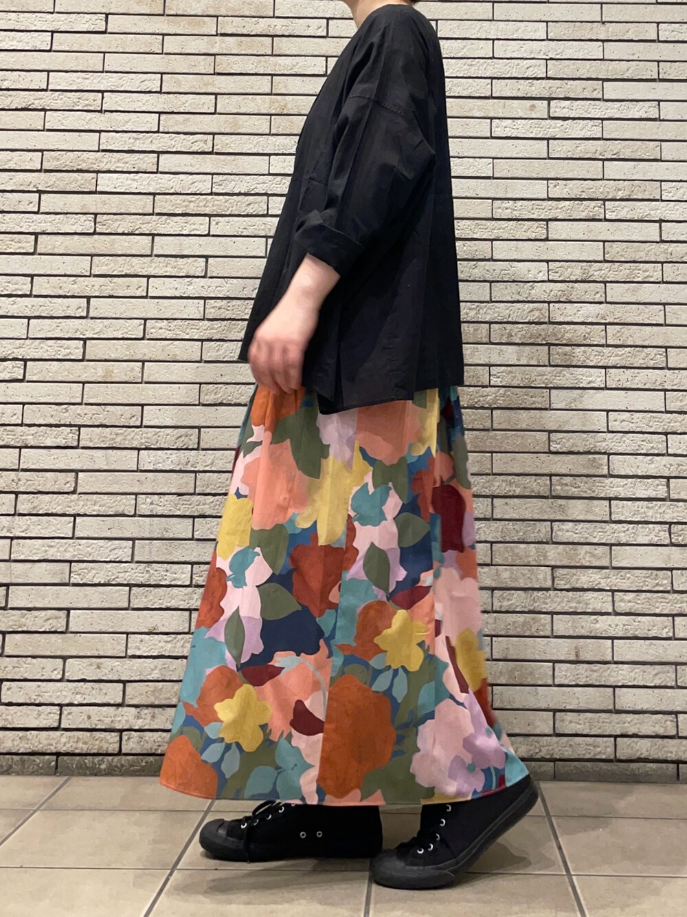 ブラック系のシャツ/ブラウス、ピンク系のスカートを着用したレディースの秋コーディネートの3枚目の写真