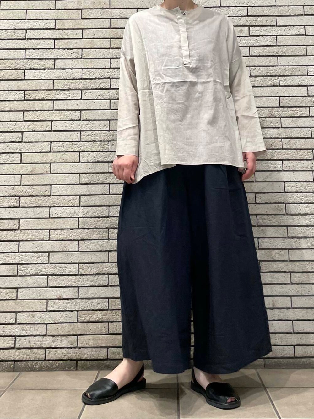 ブラック系のその他パンツ、ベージュ系のシャツ/ブラウスを着用したレディースの夏コーディネートの2枚目の写真