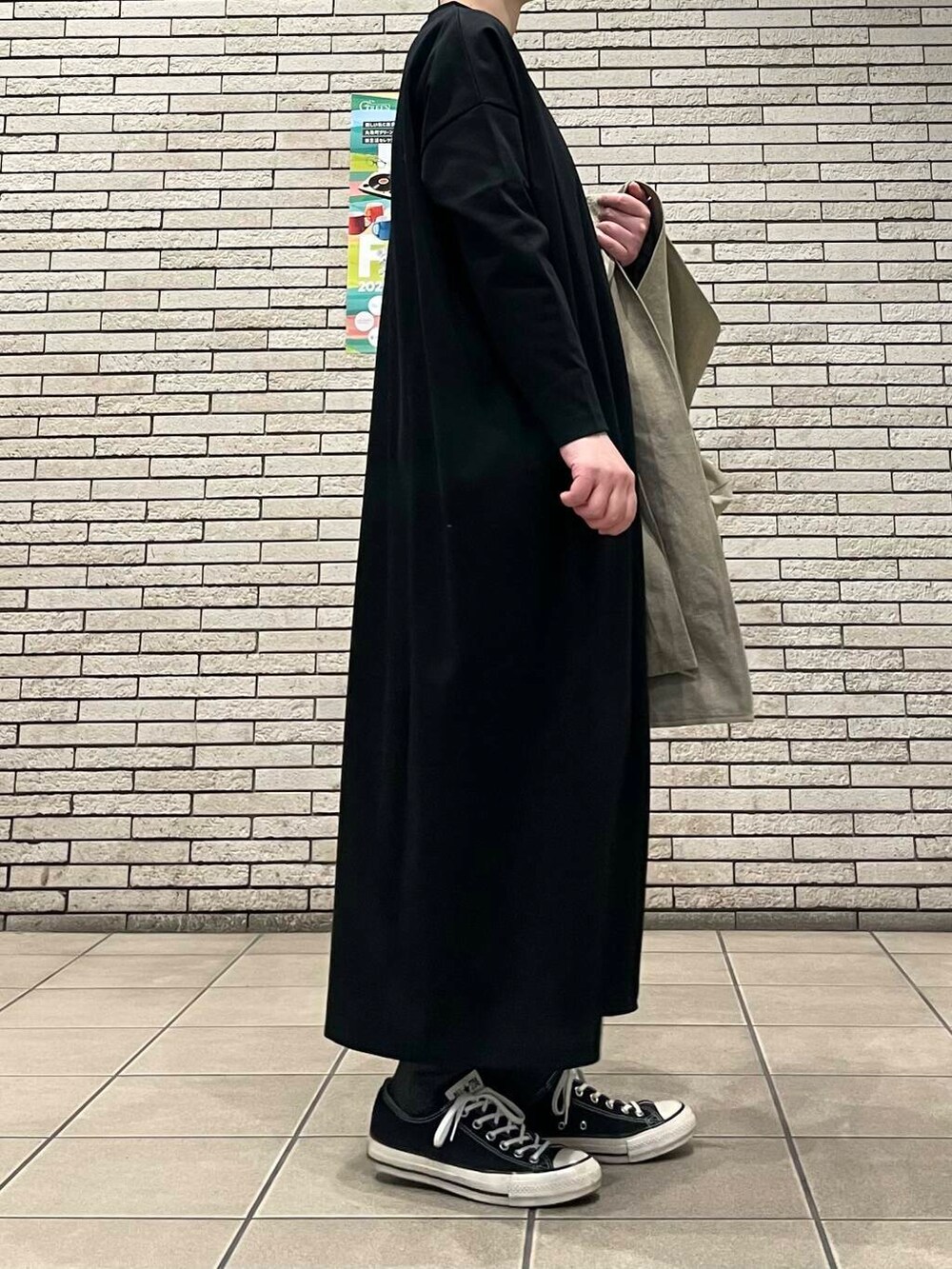 ベージュ系のトレンチコートを着用したレディースの春コーディネートの6枚目の写真