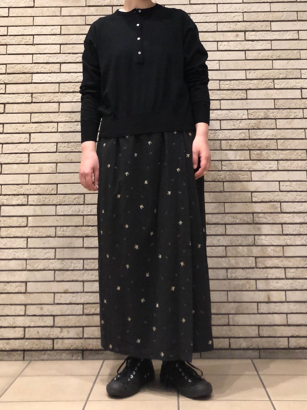 ブラック系のニット/セーター、ブラック系のスカートを着用したレディースの冬コーディネートの2枚目の写真