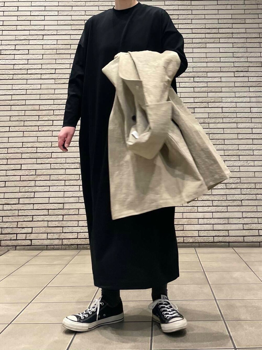 ベージュ系のトレンチコートを着用したレディースの春コーディネートの5枚目の写真