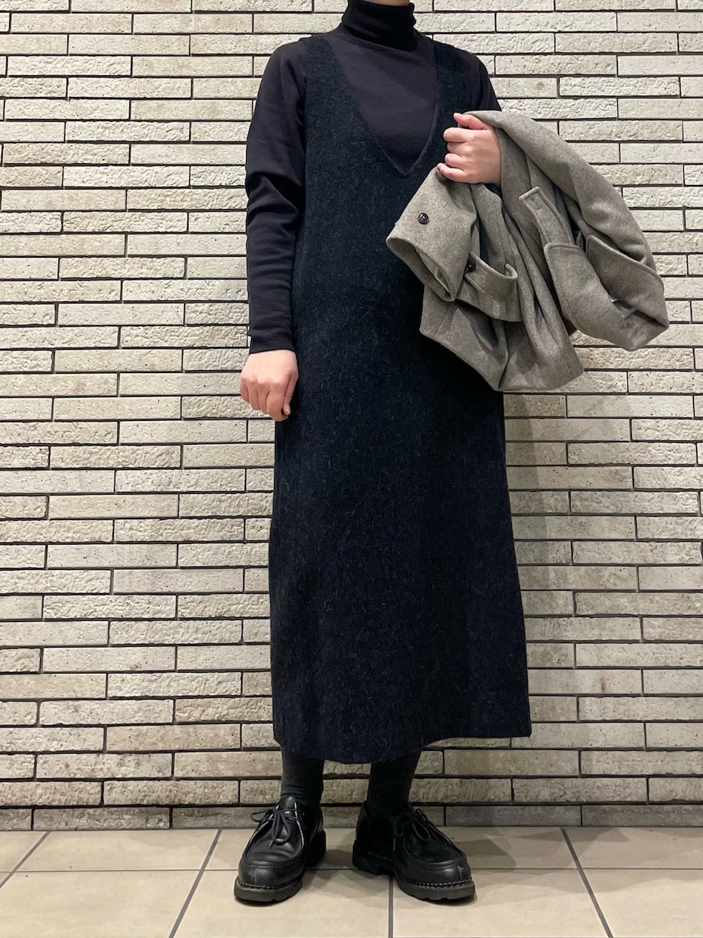 グレー系のステンカラーコート、グレー系のワンピースを着用したレディースの秋コーディネートの5枚目の写真