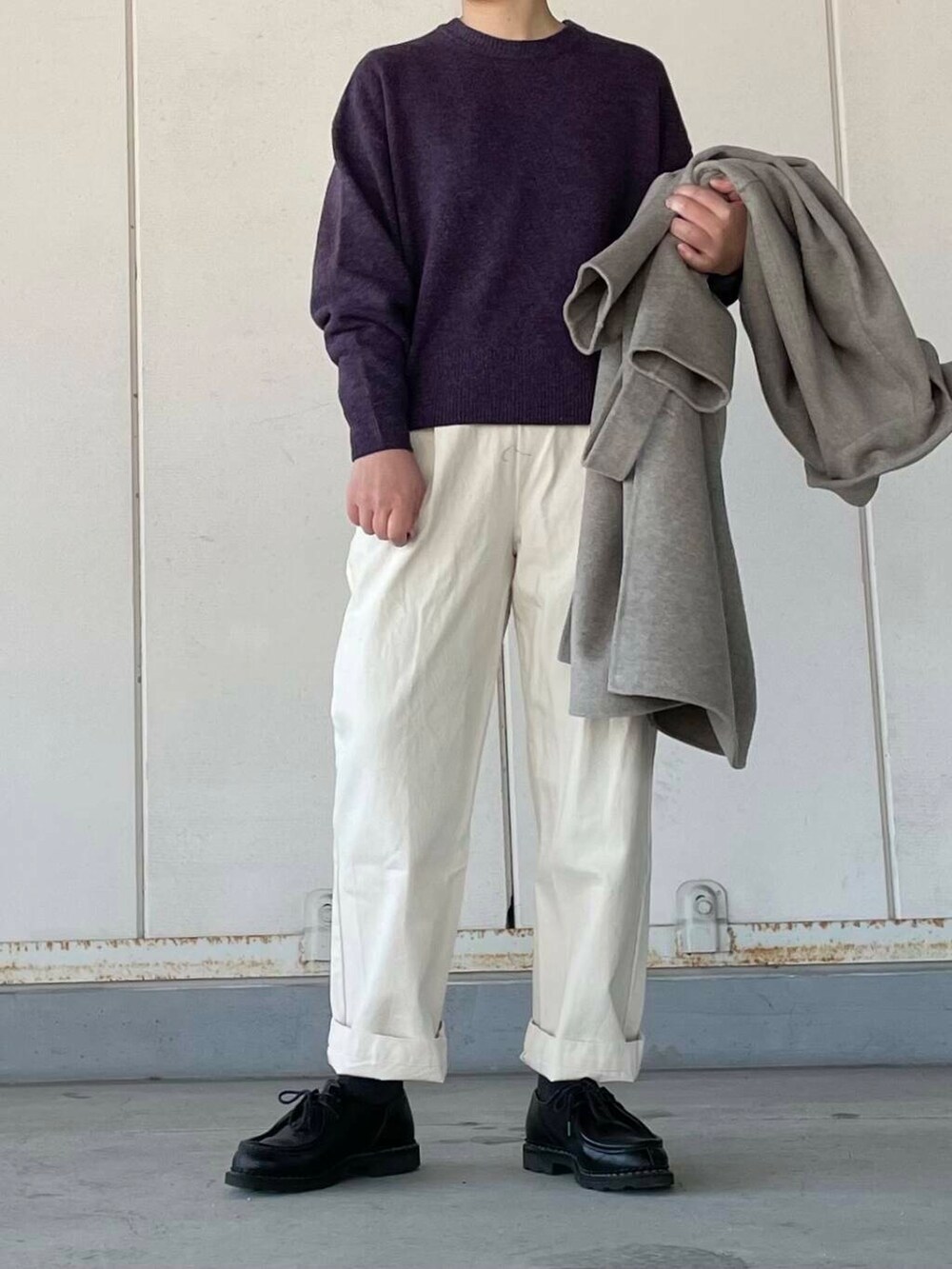 ベージュ系のデニムパンツ、グレー系のステンカラーコート、パープル系のニット/セーターを着用したレディースの冬コーディネートの5枚目の写真