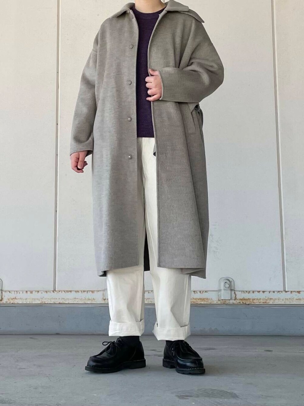 ベージュ系のデニムパンツ、グレー系のステンカラーコート、パープル系のニット/セーターを着用したレディースの冬コーディネートの2枚目の写真