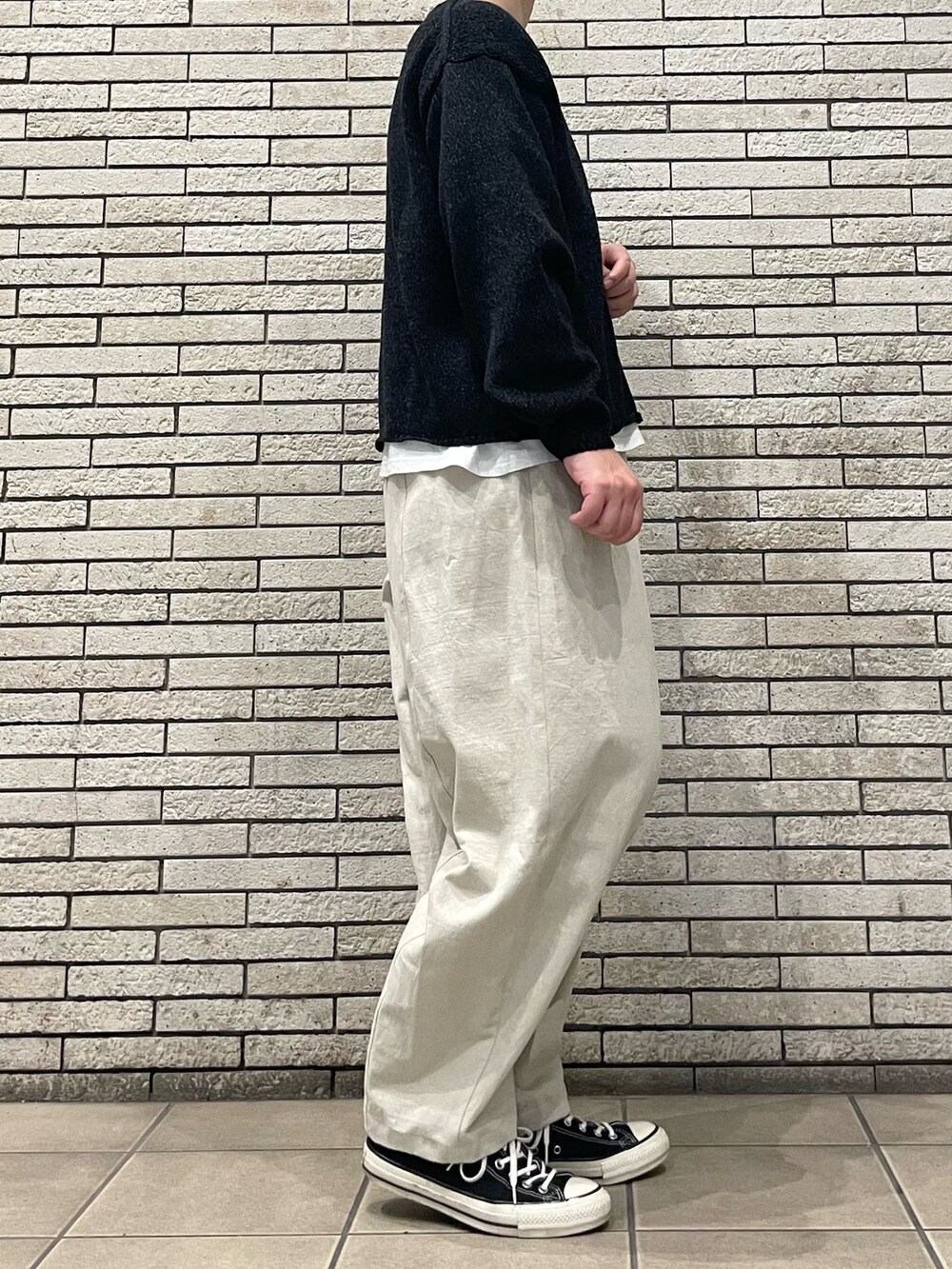 ブラック系のニット/セーター、ホワイト系のその他パンツを着用したレディースの秋コーディネートの5枚目の写真