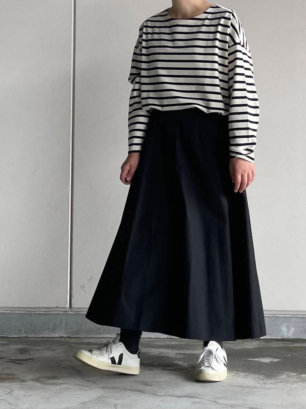 ブラック系のスカート、ホワイト系のTシャツ/カットソーを着用したレディースの秋コーディネートの5枚目の写真