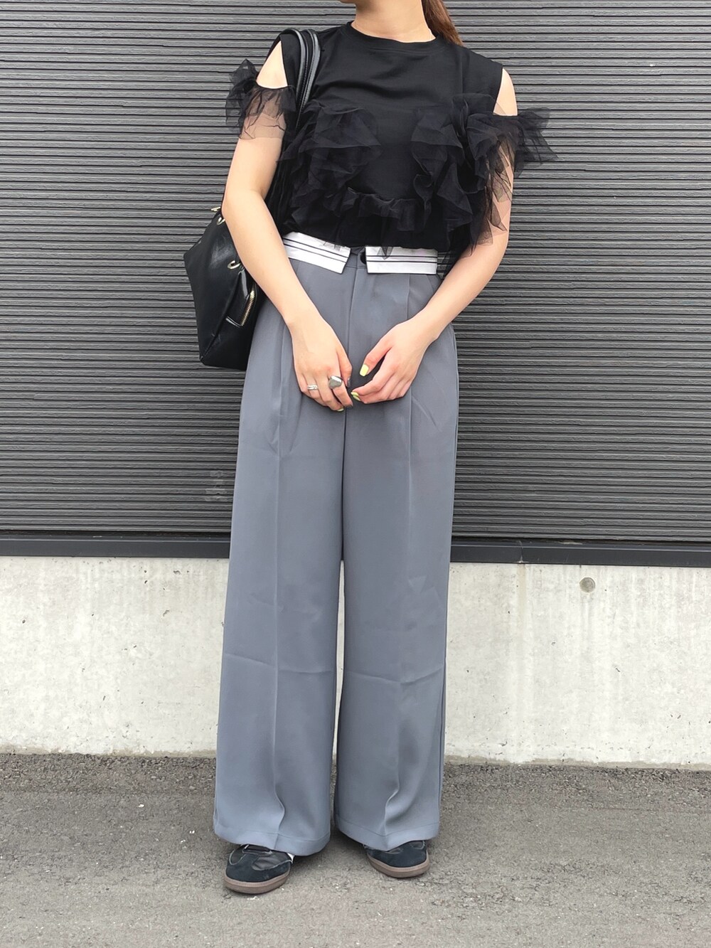 ブラック系のTシャツ/カットソー、グレー系のスラックスを着用したレディースの春コーディネートの3枚目の写真