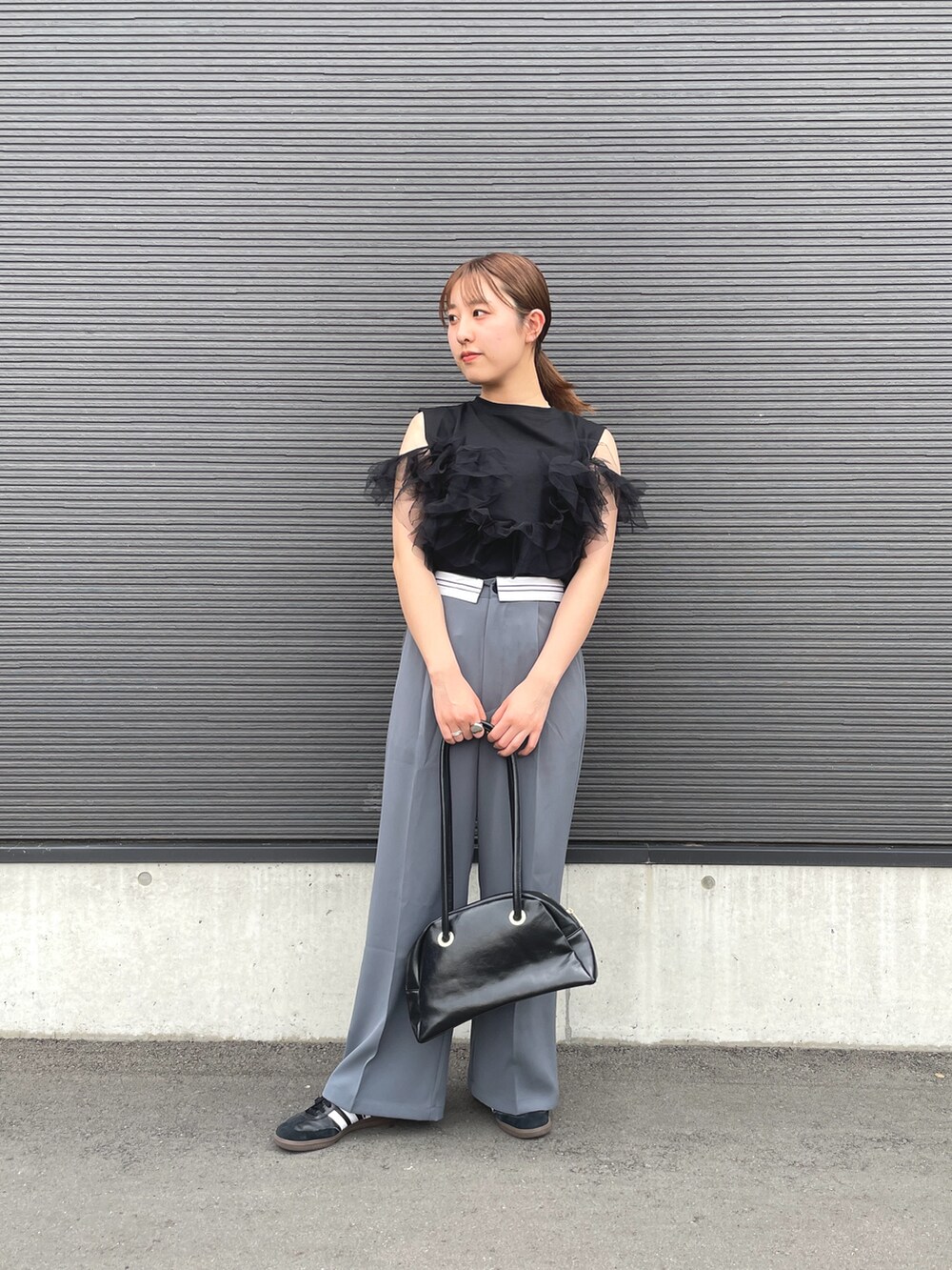 ブラック系のTシャツ/カットソー、グレー系のスラックスを着用したレディースの春コーディネートの2枚目の写真