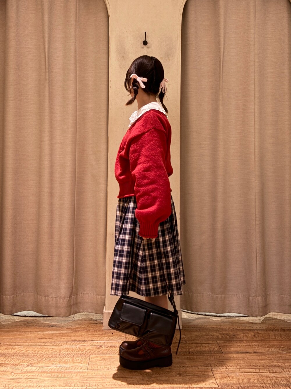 レッド系のニット/セーター、ブルー系のスカート、ブラウン系のその他シューズを着用したレディースの秋コーディネートの2枚目の写真