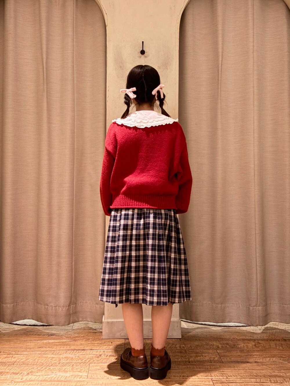 レッド系のニット/セーター、ブルー系のスカート、ブラウン系のその他シューズを着用したレディースの秋コーディネートの3枚目の写真
