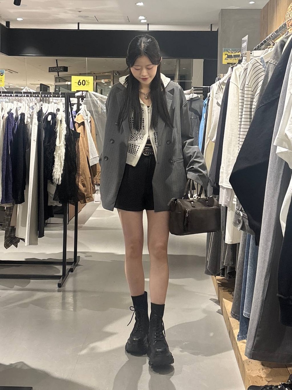 ブラック系のブーツ、ホワイト系のパーカー、グレー系のショルダーバッグを着用したレディースの春コーディネートの2枚目の写真